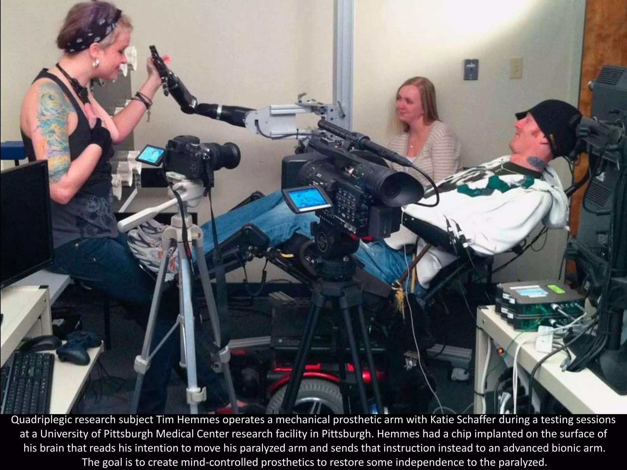 Quadriplegic research subject Tim Hemmes operates a mechanical prosthetic arm with Katie Schaffer during a testing sessions
 at a University of Pittsburgh Medical Center research facility in Pittsburgh. Hemmes had a chip implanted on the surface of
  his brain that reads his intention to move his paralyzed arm and sends that instruction instead to an advanced bionic arm.
               The goal is to create mind-controlled prosthetics to restore some independence to the paralyzed.
 