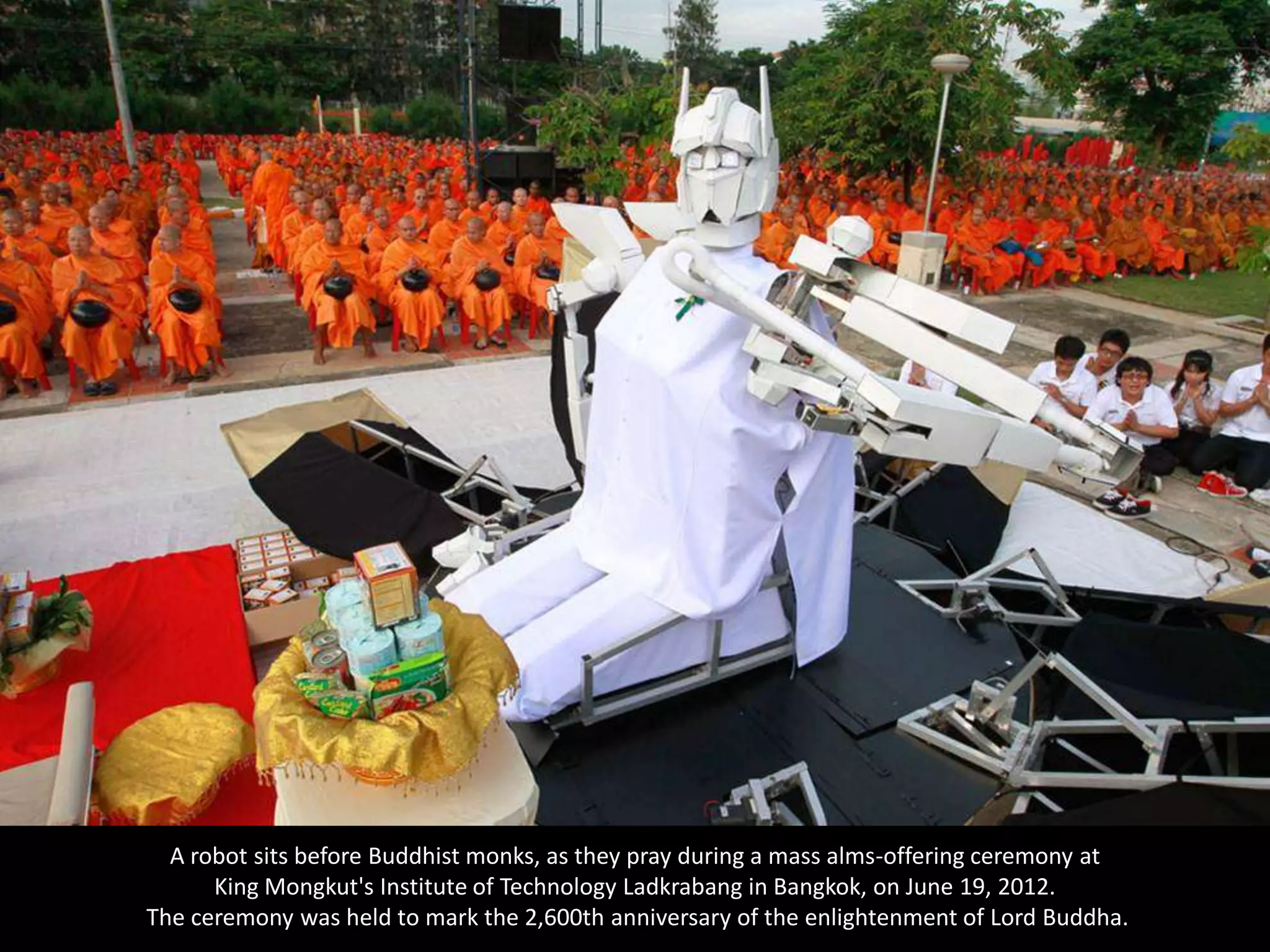 A robot sits before Buddhist monks, as they pray during a mass alms-offering ceremony at
      King Mongkut's Institute of Technology Ladkrabang in Bangkok, on June 19, 2012.
The ceremony was held to mark the 2,600th anniversary of the enlightenment of Lord Buddha.
 