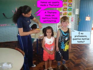 Vamos ver quanto mede a Thatiara? A Thatiara mede um metro e treze centímetros. E eu professora, quantos metros tenho? 