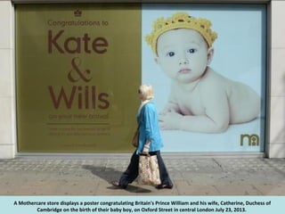 Employees Amy Meenagh (R) and Amy Bush hang a sign celebrating the news that Catherine, Duchess of Cambridge, has
given bi...