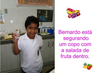 Bernardo está
segurando
um copo com
a salada de
fruta dentro.
 