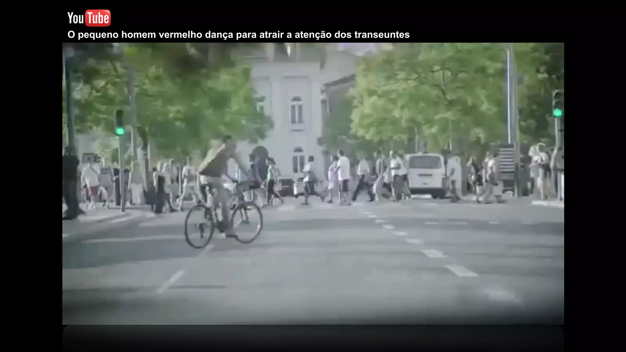 O pequeno homem vermelho dança para atrair a atenção dos transeuntes
 