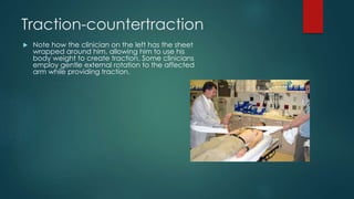 Traction-countertraction 
 Note how the clinician on the left has the sheet 
wrapped around him, allowing him to use his 
body weight to create traction. Some clinicians 
employ gentle external rotation to the affected 
arm while providing traction. 
 