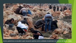 Jovens palestinos se escodem após lançarem pedras contra soldados israelenses no vilarejo de Qusra, Gaza. 
 