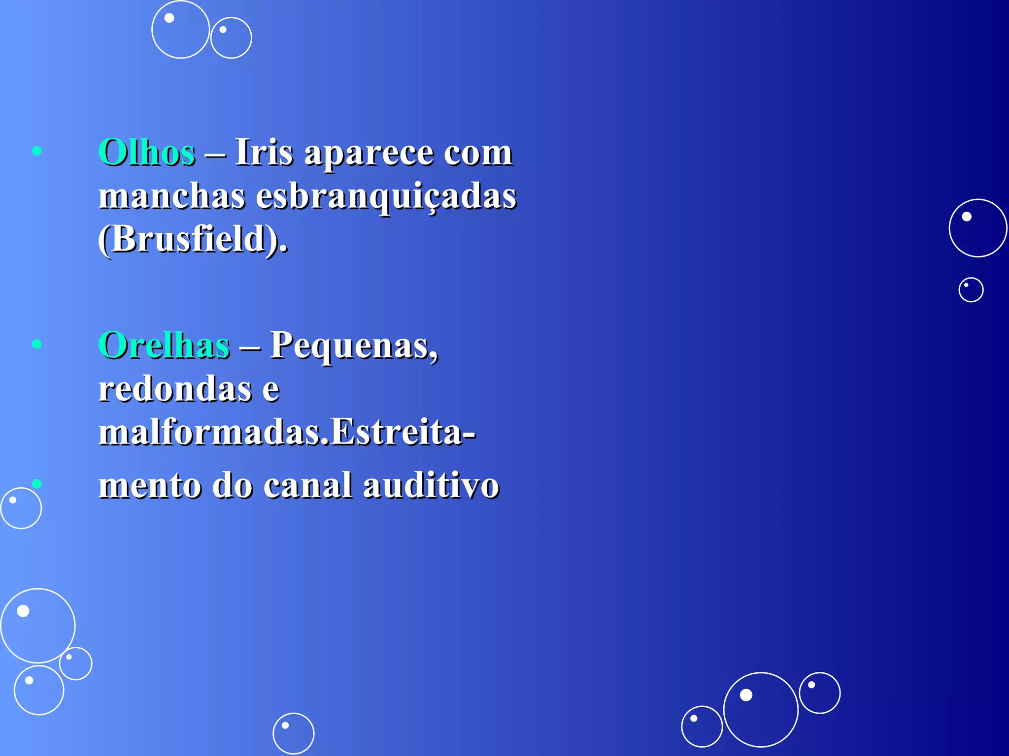 Olhos  – Iris aparece com manchas esbranquiçadas (Brusfield). Orelhas  – Pequenas, redondas e malformadas.Estreita- mento do canal auditivo 