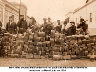 Trincheira de paralelepípedos em rua paulistana durante os intensos
                  combates da Revolução de 1924.
 