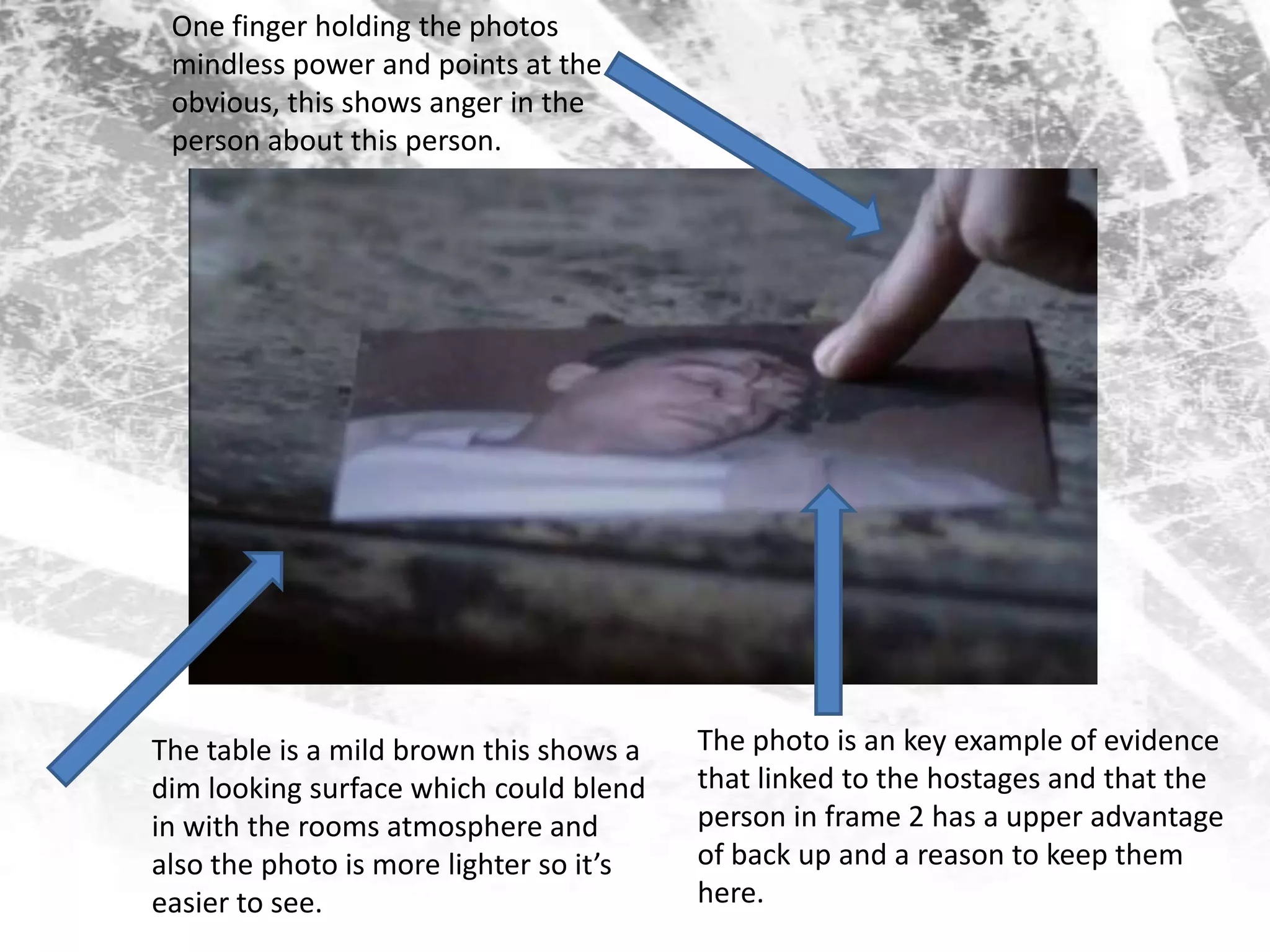 One finger holding the photos mindless power and points at the obvious, this shows anger in the person about this person.The photo is an key example of evidence that linked to the hostages and that the person in frame 2 has a upper advantage of back up and a reason to keep them here. The table is a mild brown this shows a dim looking surface which could blend in with the rooms atmosphere and also the photo is more lighter so it’s easier to see.