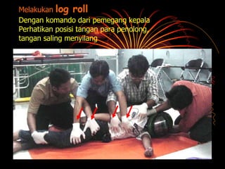 Melakukan  log roll Dengan komando dari pemegang kepala Perhatikan posisi tangan para penolong,  tangan saling menyilang 