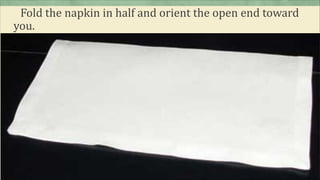 Fold the napkin in half and orient the open end toward
you.
 