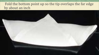 Fold the bottom point up so the tip overlaps the far edge
by about an inch
 