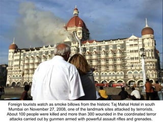 Foreign tourists watch as smoke billows from the historic Taj Mahal Hotel in south Mumbai on November 27, 2008, one of the landmark sites attacked by terrorists.  About 100 people were killed and more than 300 wounded in the coordinated terror attacks carried out by gunmen armed with powerful assault rifles and grenades.  
