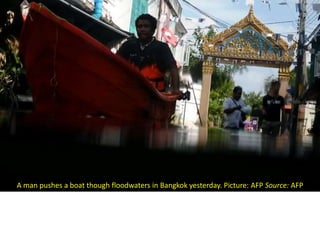 A man pushes a boat though floodwaters in Bangkok yesterday. Picture: AFP Source: AFP
 