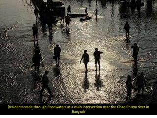 Residents wade through floodwaters at a main intersection near the Chao Phraya river in
                                      Bangkok
 