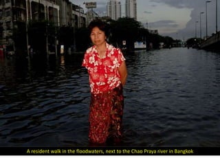 A resident walk in the floodwaters, next to the Chao Praya river in Bangkok
 