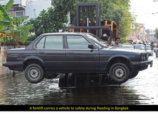 A forklift carries a vehicle to safety during flooding in Bangkok
 