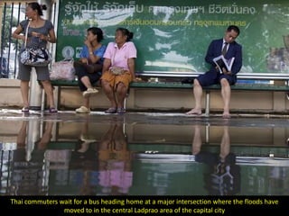 Thai commuters wait for a bus heading home at a major intersection where the floods have
                moved to in the central Ladprao area of the capital city
 