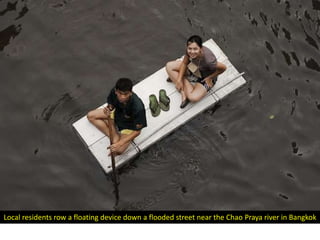 Local residents row a floating device down a flooded street near the Chao Praya river in Bangkok
 