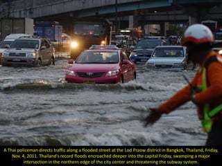 A Thai policeman directs traffic along a flooded street at the Lod Praow district in Bangkok, Thailand, Friday,
    Nov. 4, 2011. Thailand's record floods encroached deeper into the capital Friday, swamping a major
          intersection in the northern edge of the city center and threatening the subway system.
 