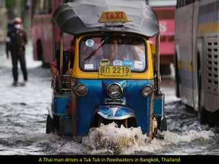 A Thai man drives a Tuk Tuk in floodwaters in Bangkok, Thailand
 