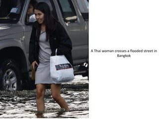A Thai woman crosses a flooded street in
              Bangkok
 
