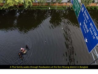 A Thai family wades through floodwaters at the Don Muang district in Bangkok
 