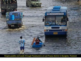 People paddle and wade through floodwaters at Lod Praow district in Bangkok, Thailand
 