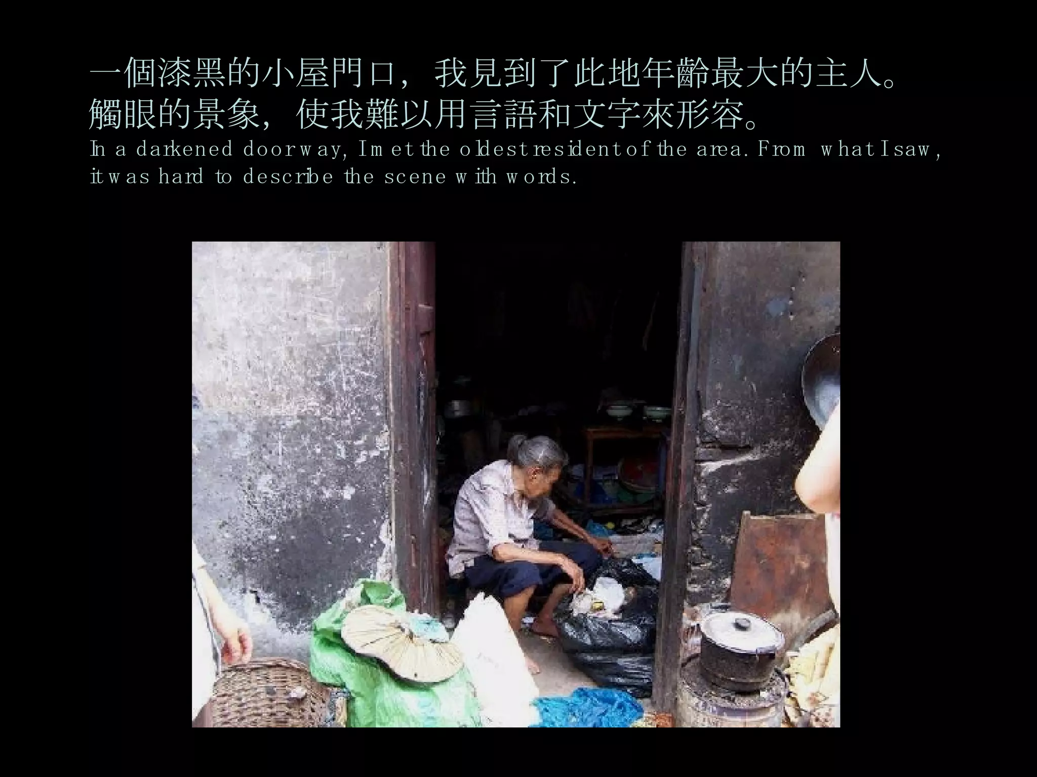 一個漆黑的小屋門口，我見到了此地年齡最大的主人。觸眼的景象，使我難以用言語和文字來形容。 In a darkened door way, I met the oldest resident of the area. From what I saw, it was hard to describe the scene with words. 