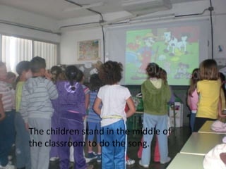 The children stand in the middle of the classroom to do the song.