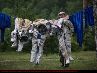 An employee of the Russian Space Training Center hangs space suits out to dry, July 2, 2014. ALEXANDER ZEMLIANICHENKO—AP
 