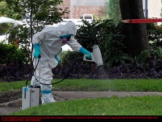 A man dressed in protective hazmat clothing treats the sidewalk in front of an apartment where a second person diagnosed w...