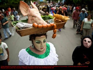 A man dressed as a woman carries a pig's head on a platter balanced on his head during the celebration of Torovenado, a sa...