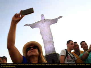 A woman poses for a selfie in front of the statue of Christ the Redeemer ahead of the 2014 World Cup in Rio de Janeiro, in...