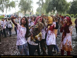 Youth covered in coloured powder pose for a selfie as they celebrate the spring festival in Baghdad March 20, 2015. (Photo...