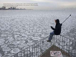 Charles Martinez sits on a railing to take a selfie overlooking the partially
frozen Lake Michigan in Chicago, Illinois, i...