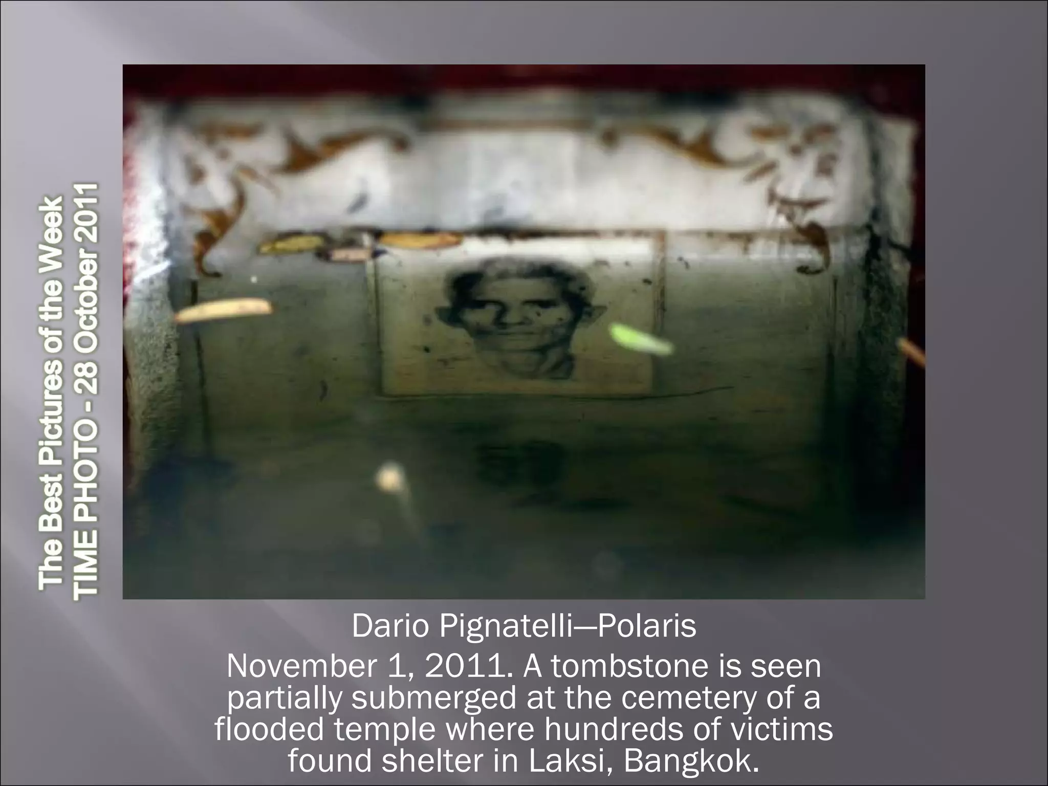 Dario Pignatelli—Polaris November 1, 2011. A tombstone is seen partially submerged at the cemetery of a flooded temple where hundreds of victims found shelter in Laksi, Bangkok. 