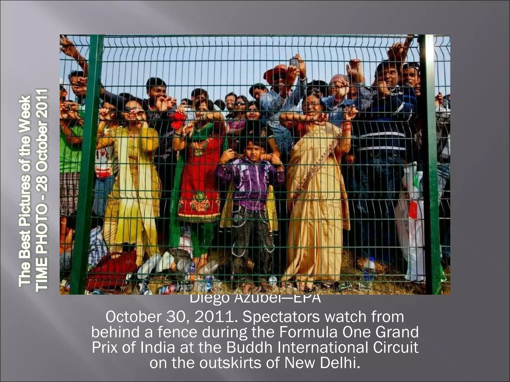 Diego Azubel—EPA October 30, 2011. Spectators watch from behind a fence during the Formula One Grand Prix of India at the Buddh International Circuit on the outskirts of New Delhi. 