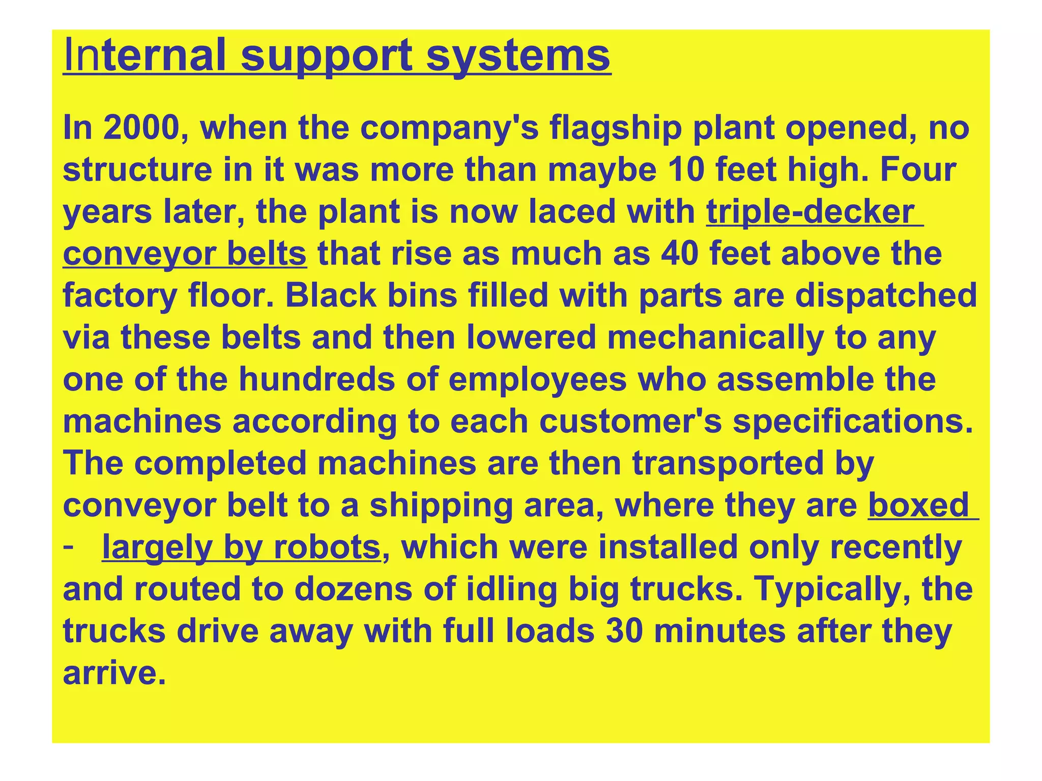 In ternal support systems In 2000, when the company's flagship plant opened, no  structure in it was more than maybe 10 feet high. Four  years later, the plant is now laced with  triple-decker  conveyor belts  that rise as much as 40 feet above the  factory floor. Black bins filled with parts are dispatched  via these belts and then lowered mechanically to any  one of the hundreds of employees who assemble the  machines according to each customer's specifications.  The completed machines are then transported by  conveyor belt to a shipping area, where they are  boxed  largely by robots , which were installed only recently and routed to dozens of idling big trucks. Typically, the  trucks drive away with full loads 30 minutes   after they  arrive.   