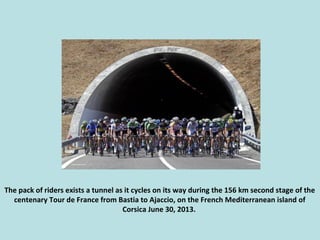 The pack of riders exists a tunnel as it cycles on its way during the 156 km second stage of the
centenary Tour de France ...