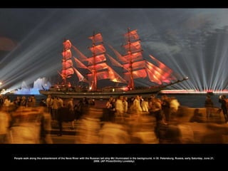 People walk along the embankment of the Neva River with the Russian tall ship Mir illuminated in the background, in St. Petersburg, Russia, early Saturday, June 21, 2008. (AP Photo/Dmitry Lovetsky) 