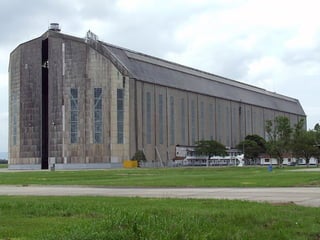 Em 1.933, os alemães vieram ao Brasil, para
  projetar um hangar para atender os dirigíveis
           alemães no Rio de Janeiro.
  Para tal, a Luftschiffbau Zeppelin recebeu um
terreno de 80 mil m², no subúrbio de Santa Cruz,
    no Rio de Janeiro, doados pelo Ministério da
Agricultura, próximo á Baía de Sepetiba.
             Lá foi construído um aeroporto para
 dirigíveis, ao qual foi dado o nome de Bartolomeu
 de Gusmão, em homenagem ao pioneiro balonista
                      brasileiro.
  Tal hangar, pré-fabricado, foi construído pela
   Guttehoffnungshutte Aktien Geselschaft, na
   Alemanha, transportado por vida marítima e
     montado em Santa Cruz pela Companhia
    Construtora Nacional, durante 23 meses,
 