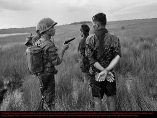 A South Vietnamese soldier holds a cocked pistol as he questions two suspected Viet Cong guerrillas captured in a weed-filled marsh in the southern delta region
late in August 1962. The prisoners were searched, bound and questioned before being marched off to join other detainees. (AP Photo/Horst Faas)
 