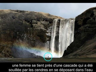 une femme se tient près d'une cascade qui a été souillée par les cendres en se déposant dans l’eau 