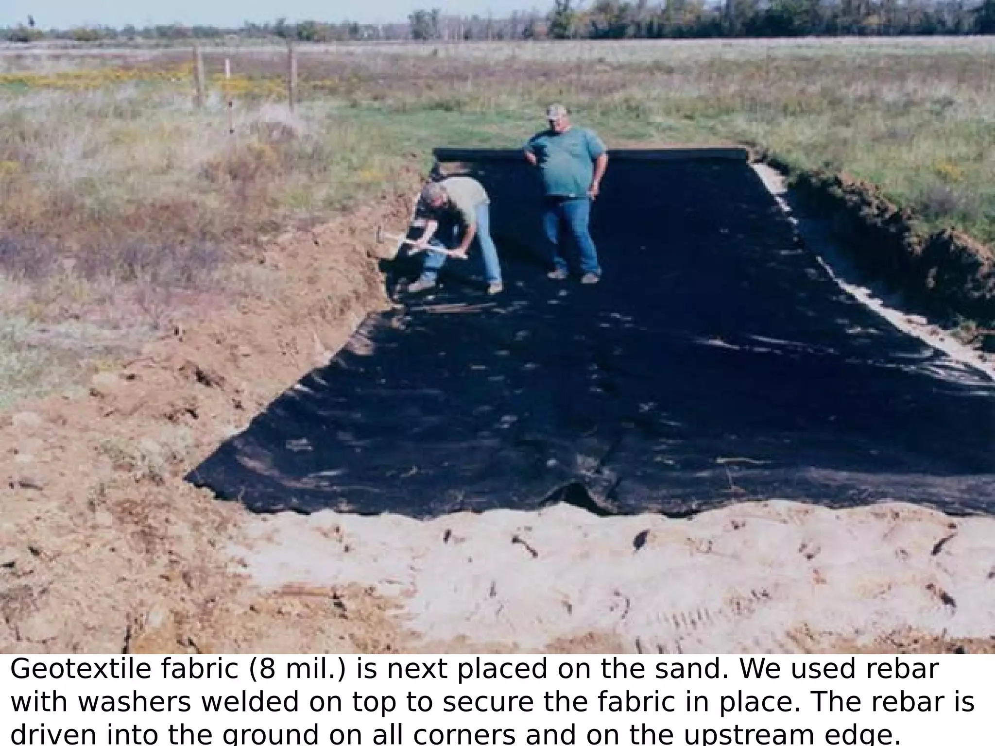 Geotextile fabric (8 mil.) is next placed on the sand. We used rebar
with washers welded on top to secure the fabric in place. The rebar is
driven into the ground on all corners and on the upstream edge.

 