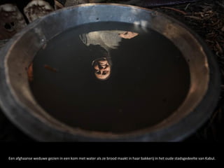 Een afghaanse weduwe gezien in een kom met water als ze brood maakt in haar bakkerij in het oude stadsgedeelte van Kabul.
 