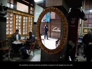 Een winkelier uit Caïro stalt zijn produkten uit gezien in de spiegel van een café.
 