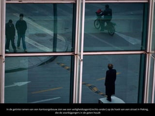 In de getinte ramen van een kantoorgebouw zien we een veiligheidsagent(rechts-onder) op de hoek van een straat in Peking,
                                        die de voorbijgangers in de gaten houdt
 