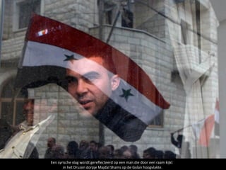 Een syrische vlag wordt gereflecteerd op een man die door een raam kijkt
       in het Druzen dorpje Majdal Shams op de Golan hoogvlakte.
 