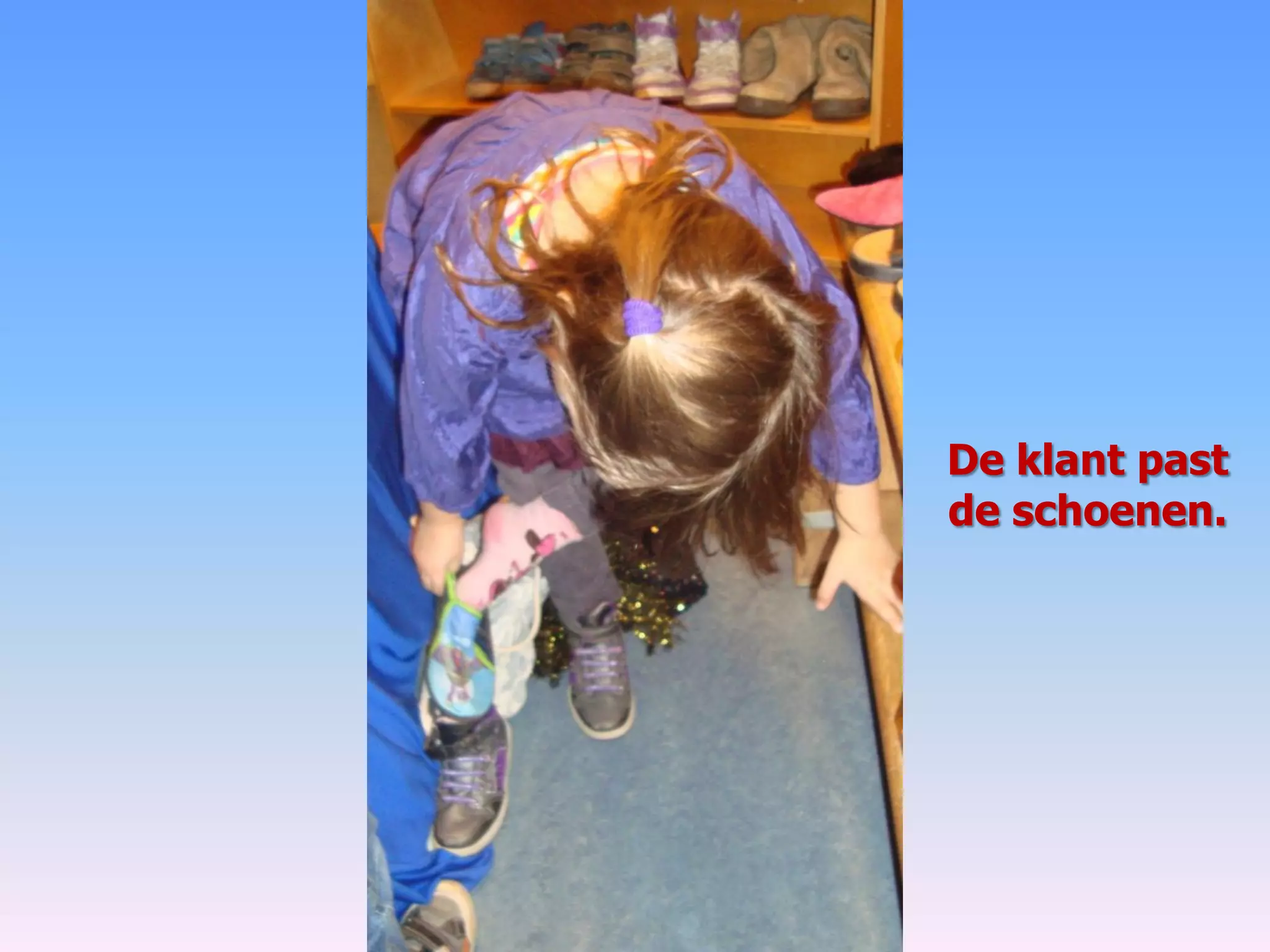 De klant past
de schoenen.
 