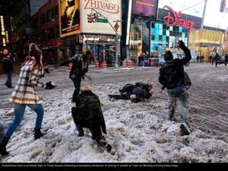 Pedestrians have a snowball fight in Times Square following a mandatory shutdown of driving in streets at 11pm on Monday e...