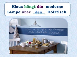 Klaus hängt die moderne
Lampe über ______ Holztisch.den
 